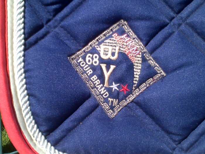 Tapis de selle HKM bleu marine + bordures framboise